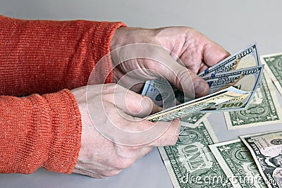 Caucasian man`s hands counting dollar banknotes Stock Photo