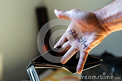 Caucasian man showing hes empty wallet, the word hate is written on hes palm Stock Photo