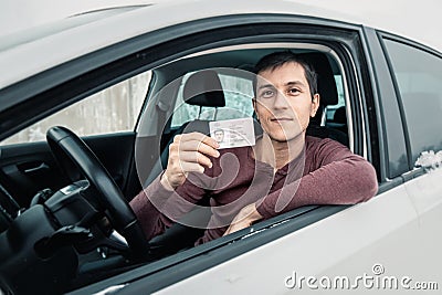 Man shows his driver`s license in the car window immediately after passing the exam or at the request of the traffic Stock Photo