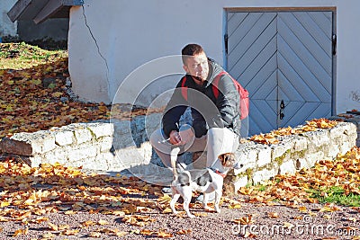 Caucasian man walking with jack russell terrier dog in autumnal park Stock Photo