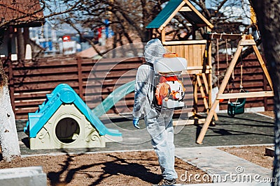 man wearing protective hazmat suit spraying disinfectant and chemicals. Decontamination. Protection and prevention amid Stock Photo