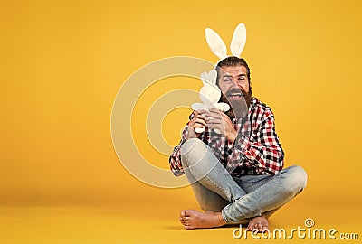 Caucasian mature hipster in buny ears with trendy hairstyle in checkered shirt celebrate easter, copy space, easter joy Stock Photo