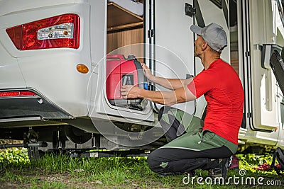 Men Removing Portable Gas Generator From His Camper Van RV Storage Area Stock Photo