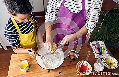 Caucasian mother teaching her son how to cook preparing the ingredients to make a cake Stock Photo