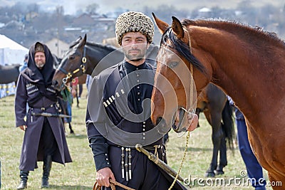 Caucasian mountaineer in national costume with his horse. Editorial Stock Photo