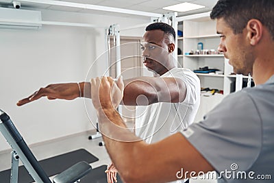 Qualified physiotherapist assessing patient upper body strength Stock Photo