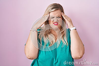 Caucasian plus size woman standing over pink background with hand on head, headache because stress Stock Photo