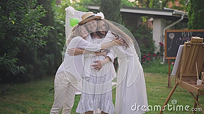Caucasian pregnant woman standing on backyard as young and teenage girls hugging expectant smiling. Portrait of positive stock video Caucasian pregnant woman standing on backyard as young and teenage girls hugging expectant smiling. Portrait of positive stock video