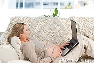 Caucasian pregnant woman working on a laptop Stock Photo