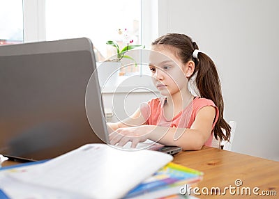 Caucasian preteen girl concentrated on her task with laptop. Concept of distance learning in isolation while coronavirus Stock Photo