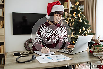 Caucasian remote employee starting day at home decorated with Christmas tree Stock Photo