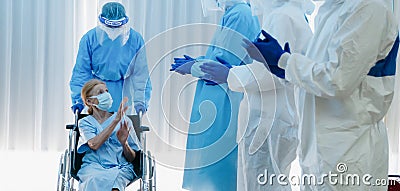 Caucasian senior coronavirus covid-19 infected patient sitting on wheel chair with happy doctor and medical team ready to send her Stock Photo