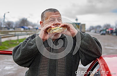 Caucasian senior driver gobbling lyulya kebab in lavash Stock Photo