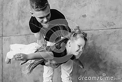 Caucasian siblings - teenager boy brother and little girl sister playing in aircraft in modern loft Stock Photo