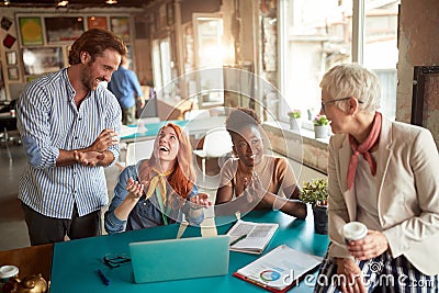 Caucasian team, different ages, talking, smiling, having a good time while working Stock Photo