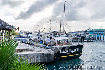 Caucasian tourists on Black Stallion Road Bay tour boat in boatyard Crew unties ropes from marine bollards for sailing Editorial Stock Photo