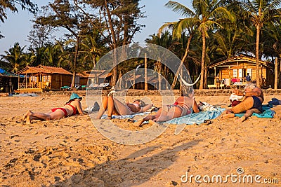 Caucasian Tourists and families relaxing and enjoying on the beach at Agonda Beach in Goa, India Editorial Stock Photo