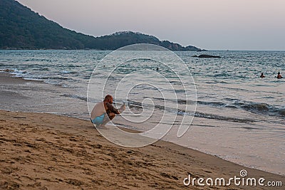 Caucasian Tourists and families relaxing and enjoying on the beach at Agonda Beach in Goa, India Editorial Stock Photo