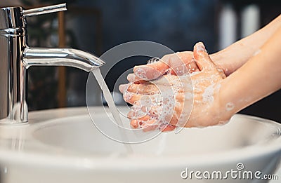 caucasian woman carefully washing hands with soap and sanitiser in home bathroom Stock Photo