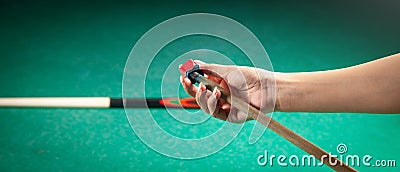 Caucasian woman chalking billiard cue Stock Photo