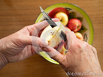 Caucasian Woman Coring an Apple with a Tin Bowl with Apples in t Stock Photo