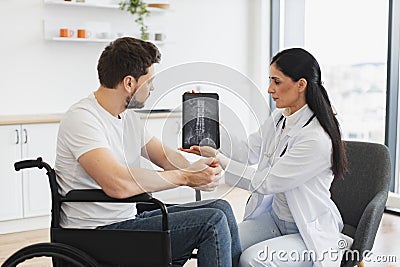Caucasian woman doctor checking up condition of mature male patient at home. Stock Photo