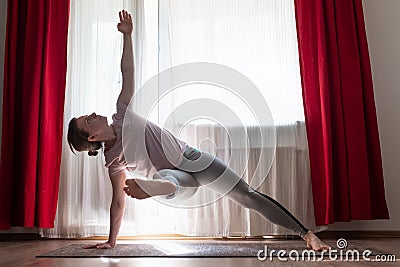 Caucasian woman doing Vasisthasana variation or Side Plank yoga pose Stock Photo