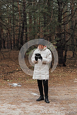 Caucasian woman flying aerial drone in autumn forest. Tech savvy middle age woman. Hobby modern Stock Photo