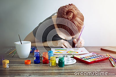 Caucasian woman girl drawing painting with watercolor paintbrush on paper. Art studio workplace concept Stock Photo