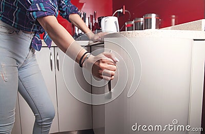 Caucasian woman opens the kitchen door furniture Stock Photo