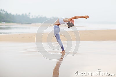 Caucasian woman practicing yoga at seashore of tropic ocean Stock Photo