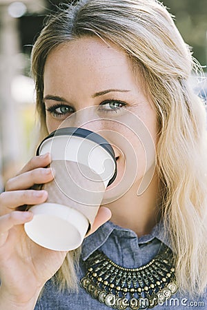 Caucasian Woman Sipping Coffee While Smiling Stock Photo