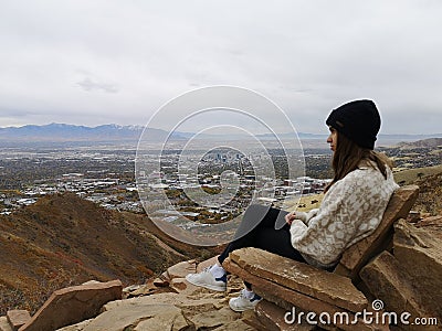 Caucasian woman sitting on a rocky chair enjoying the view from Living Room Trailhead hike Stock Photo
