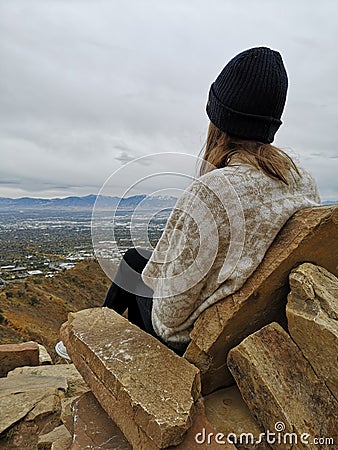 Caucasian woman sitting on a rocky sofa enjoying the view from Living Room Trailhead hike Stock Photo