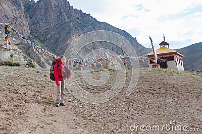 Caucasian woman trekker in Himalayan mountains near stupa, Ladakh, India Stock Photo