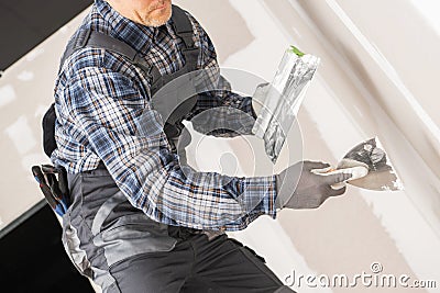 Caucasian Worker Patching Drywall Stock Photo