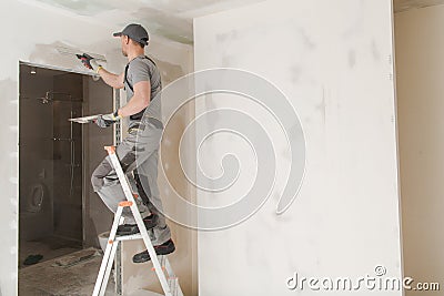 Worker Patching Drywall Stock Photo