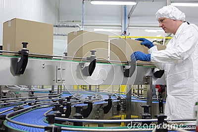 worker in white apron at packing line Stock Photo