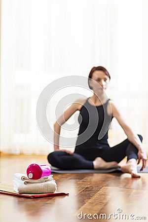 Caucasian Yoga Woman Blurred on Background. Sport Accessories in Foreground In Focus Stock Photo