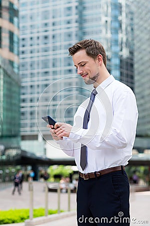 Caucasian young businessman read on the cellphone at hong kong Stock Photo
