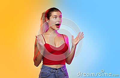 Caucasian young woman`s portrait on gradient studio background in neon Stock Photo