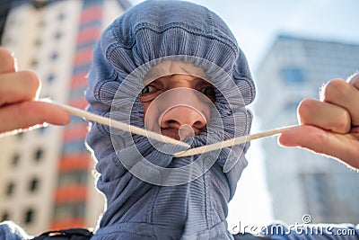 Caucasianyoung man hiding unshaven face with hood. Secrecy and mystery. Stock Photo