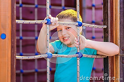 Caucasoid sporty cheerful boy playing on a wooden Playground Stock Photo