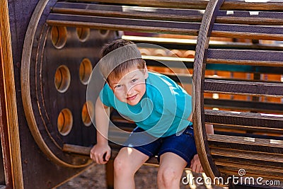 Caucasoid sporty cheerful boy playing on a wooden Playground Stock Photo