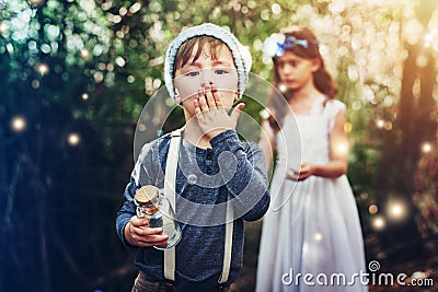 We caught so many fairies. Portrait of two little siblings catching fireflies in jars outside. Stock Photo