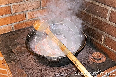 Cauldron with boiling food in heavy smoke. Stock Photo