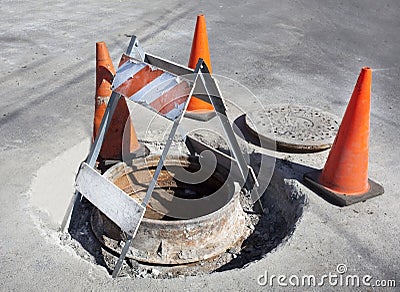 Caution cones marking sewer drainage repair site. Stock Photo