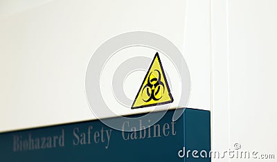 The Caution sign `Biological Hazardâ€ for warning inflected biohazard area, a safety sign warning on biosafety cabinet in lab. Stock Photo