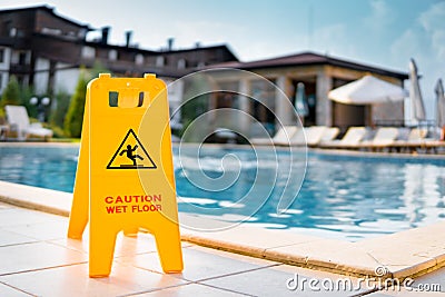 Caution wet floor warning sign near pool Stock Photo
