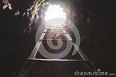 Cave hole with rustic ladder on wood and the light in out hole Stock Photo